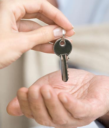 El propietario de una vivienda en alquiler entregando la llave al inquilino