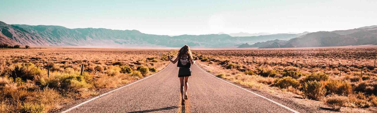 Una mujer jóven  haciendo fotos en una carretera de EEUU