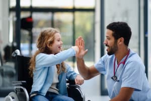 doctor haciendo reír a una niña tras necesitar asistencia médica de viaje