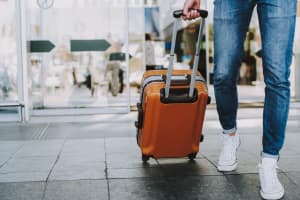 turista saliendo del aeropuerto con su maleta de viaje en suiza